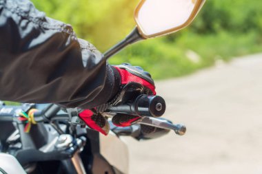 Motosikletli bir adam eldivenli, motorsiklet gaz kontrolü ve güvenlik için önemli bir koruyucu giysidir.