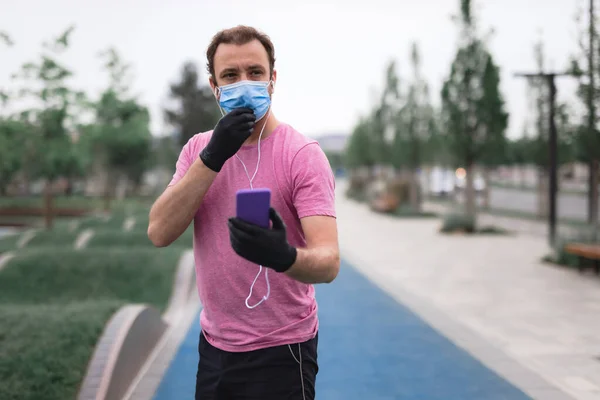 Sportman Met Medisch Masker Handschoenen Smartphone Oordopjes Aan Het Trainen — Stockfoto