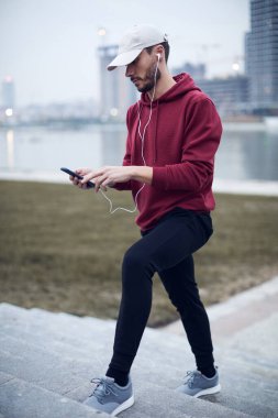 Şehir parkında kapüşonlu sweatshirt 'le antrenman yapan atletik sporcu..