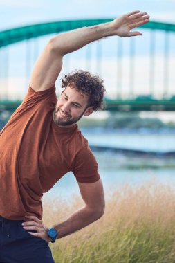 Genç sporcu, şehir ortamında egzersiz yaptıktan sonra geriniyor..