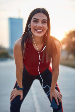 Cep telefonlu modern genç kadın koşu / egzersiz sırasında mola veriyor.