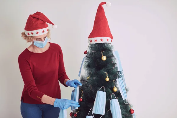 Mujer Decorando Árbol Navidad Con Máscaras Médicas Durante Pandemia Virus —  Fotos de Stock