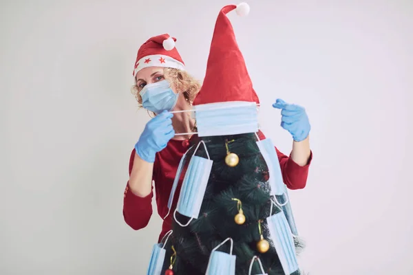 Γυναίκα Διακόσμηση Χριστουγεννιάτικο Δέντρο Ιατρικές Μάσκες Κατά Διάρκεια Πανδημίας Του — Φωτογραφία Αρχείου