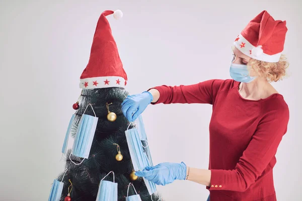 Mujer Decorando Árbol Navidad Con Máscaras Médicas Durante Pandemia Virus —  Fotos de Stock