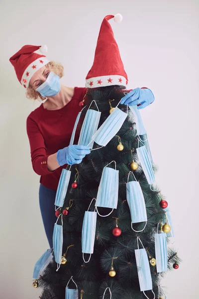 Mujer Decorando Árbol Navidad Con Máscaras Médicas Durante Pandemia Virus —  Fotos de Stock