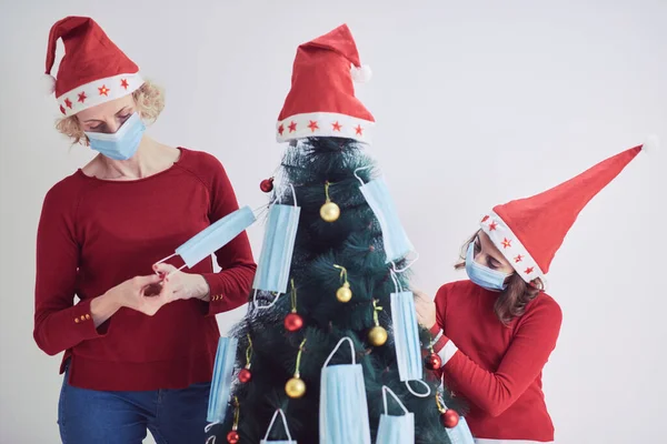 Madre Figlia Che Decorano Albero Natale Con Maschere Mediche Durante — Foto Stock