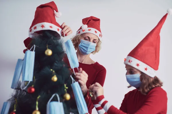 Madre Hija Decorando Árbol Navidad Con Máscaras Médicas Durante Pandemia —  Fotos de Stock