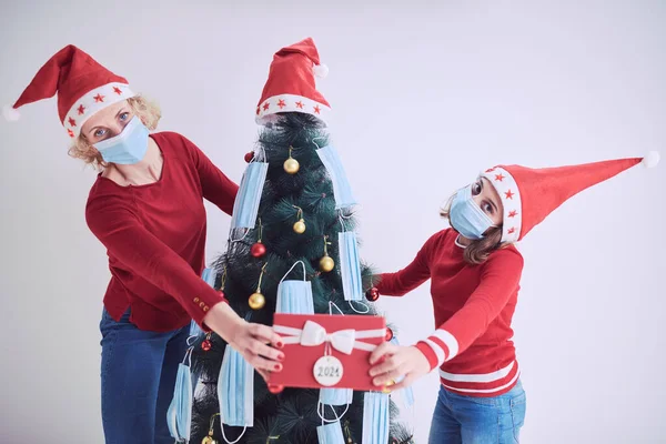 Madre Hija Decorando Árbol Navidad Con Máscaras Médicas Durante Pandemia —  Fotos de Stock