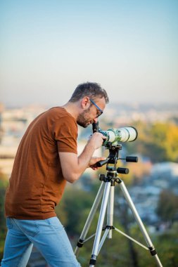 Amatör astronom teleskopla gökyüzüne bakıyor..