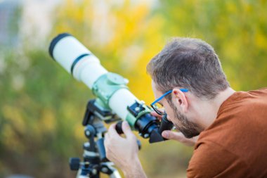 Amatör astronom teleskopla gökyüzüne bakıyor..
