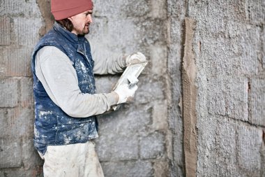 Yeni evin içindeki duvarda çalışan gerçek bir inşaat işçisi..