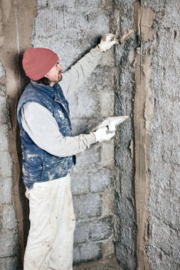 Yeni evin içindeki duvarda çalışan gerçek bir inşaat işçisi..