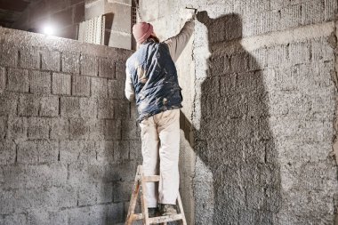 Yeni evin içindeki duvarda çalışan gerçek bir inşaat işçisi..