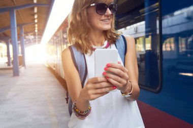 Tren istasyonunda cep telefonu kullanan bir kadın..