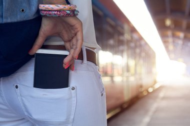 Tren istasyonunda cep telefonu kullanan bir kadın..