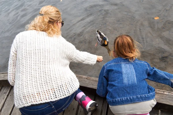 母女在湖中喂鸭 — 图库照片