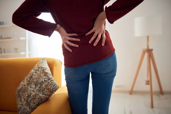 Woman with back / hip pain at home.