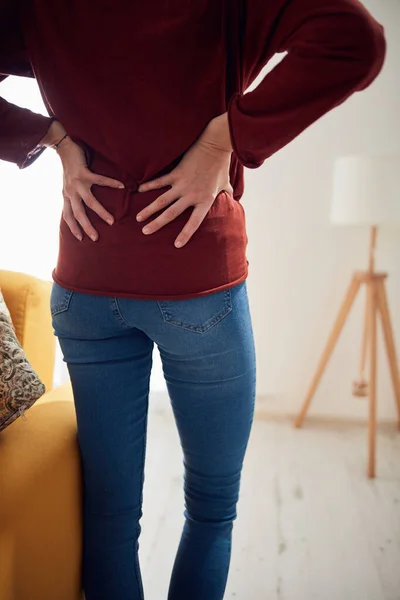 Woman with back / hip pain at home.