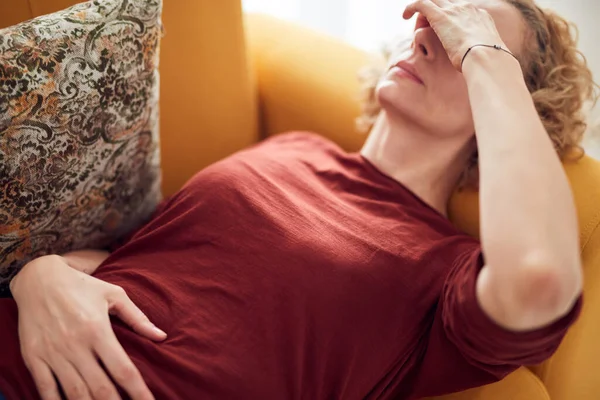 患鼻窦炎 头痛和胃问题的妇女 躺在家里的沙发上 — 图库照片