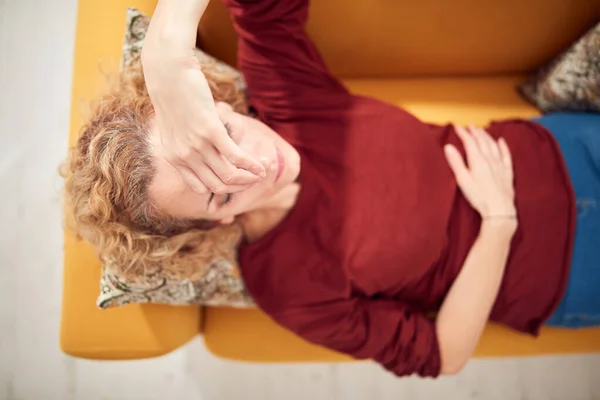 患鼻窦炎 头痛和胃问题的妇女 躺在家里的沙发上 — 图库照片