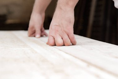 Erkek marangoz garajda ahşap malzemelerle çalışıyor..