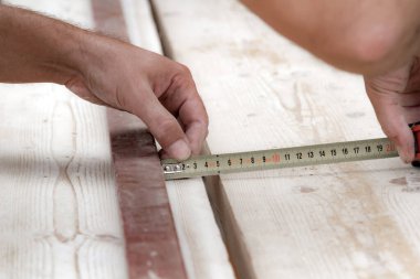 Erkek marangoz garajda ahşap malzemelerle çalışıyor..