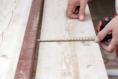 Erkek marangoz garajda ahşap malzemelerle çalışıyor..