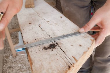 Erkek marangoz garajda ahşap malzemelerle çalışıyor..