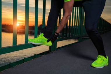 Nehrin yukarısındaki köprüde egzersiz yapan sportif bir adam..