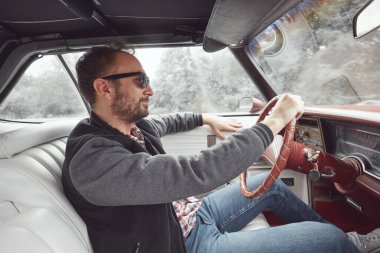 Antika elbiseli bir adam klasik Amerikan arabası kullanıyor..