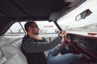 Antika elbiseli bir adam klasik Amerikan arabası kullanıyor..