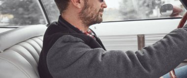 Antika elbiseli bir adam klasik Amerikan arabası kullanıyor..