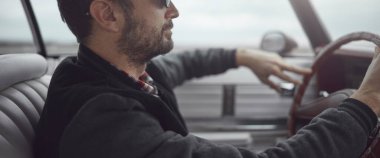 Antika elbiseli bir adam klasik Amerikan arabası kullanıyor..