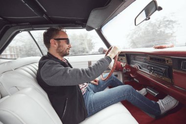 Antika elbiseli bir adam klasik Amerikan arabası kullanıyor..