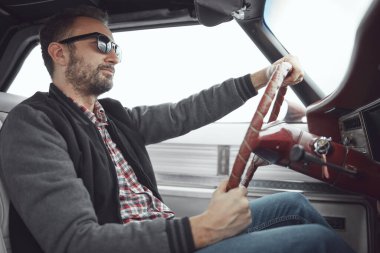 Antika elbiseli bir adam klasik Amerikan arabası kullanıyor..