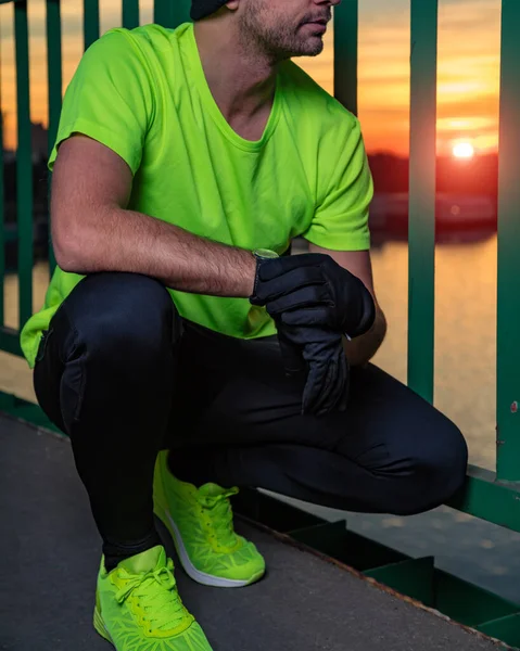 Nehrin yukarısındaki köprüde egzersiz yapan sportif bir adam..