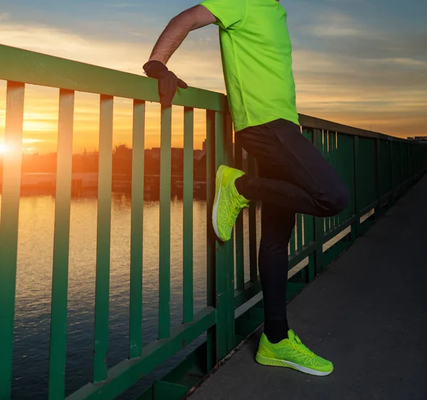 Nehrin yukarısındaki köprüde egzersiz yapan sportif bir adam..