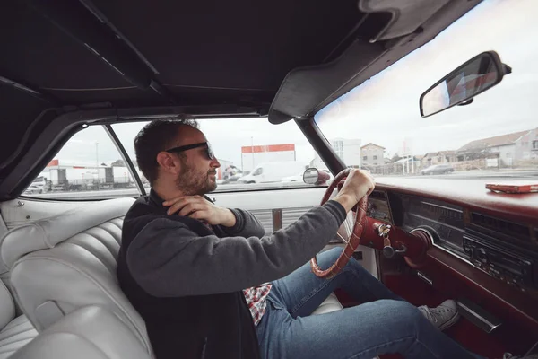 Antika elbiseli bir adam klasik Amerikan arabası kullanıyor..