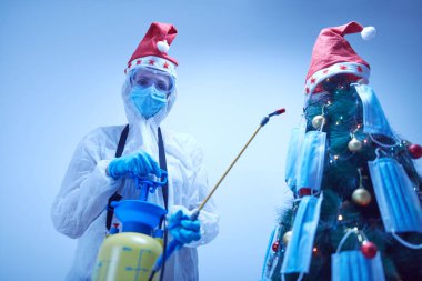 Mikropların ilaçla dezenfekte edilmesi. Covid 19 / Coronavirus salgını sırasında karantinada Noel ve yeni yıl arifesini kutlamak.