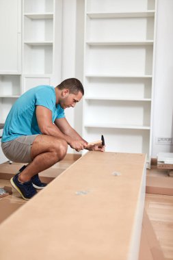 Tamirci yeni dairede mobilya montajı yapıyor, taşınıyor ve çok çalışıyor..