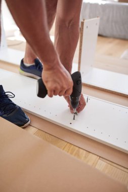 Tamirci yeni dairede mobilya montajı yapıyor, taşınıyor ve çok çalışıyor..