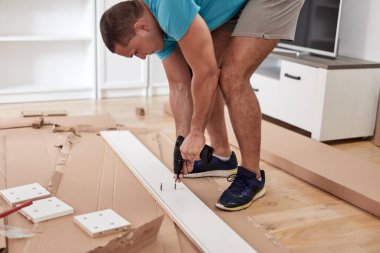 Tamirci yeni dairede mobilya montajı yapıyor, taşınıyor ve çok çalışıyor..