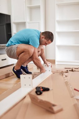 Tamirci yeni dairede mobilya montajı yapıyor, taşınıyor ve çok çalışıyor..