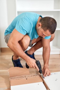 Tamirci yeni dairede mobilya montajı yapıyor, taşınıyor ve çok çalışıyor..