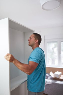 Tamirci yeni dairede mobilya montajı yapıyor, taşınıyor ve çok çalışıyor..