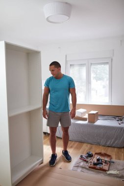 Tamirci yeni dairede mobilya montajı yapıyor, taşınıyor ve çok çalışıyor..