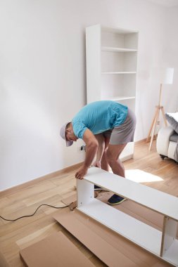 Tamirci yeni dairede mobilya montajı yapıyor, taşınıyor ve çok çalışıyor..