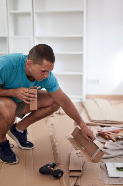 Tamirci yeni dairede mobilya montajı yapıyor, taşınıyor ve çok çalışıyor..