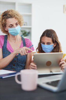 Virüsler, grip ve mevsimsel salgın zamanında özel öğretmen / anneyle evde eğitim görüyor..
