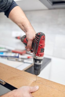 Tamirci yeni dairede mobilya montajı yapıyor, taşınıyor ve çok çalışıyor..